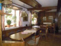 Tradične zariaden&aacute; izba s dreven&yacute;m n&aacute;bytkom, rastlinami na parapete a z&aacute;vesn&yacute;mi lampami.