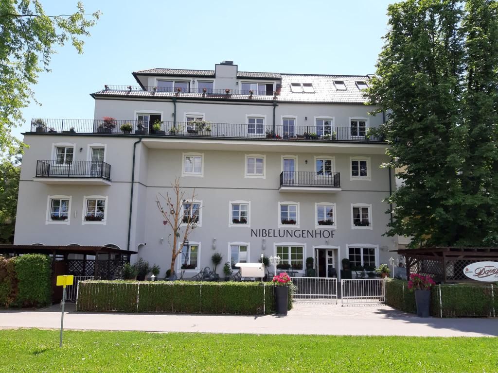 Pohľad na hotel zvonku so zelenou lúkou v popredí a modrou imelou 