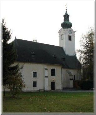 Kostol s vežou a zelenou strechou v Schwadorfe.