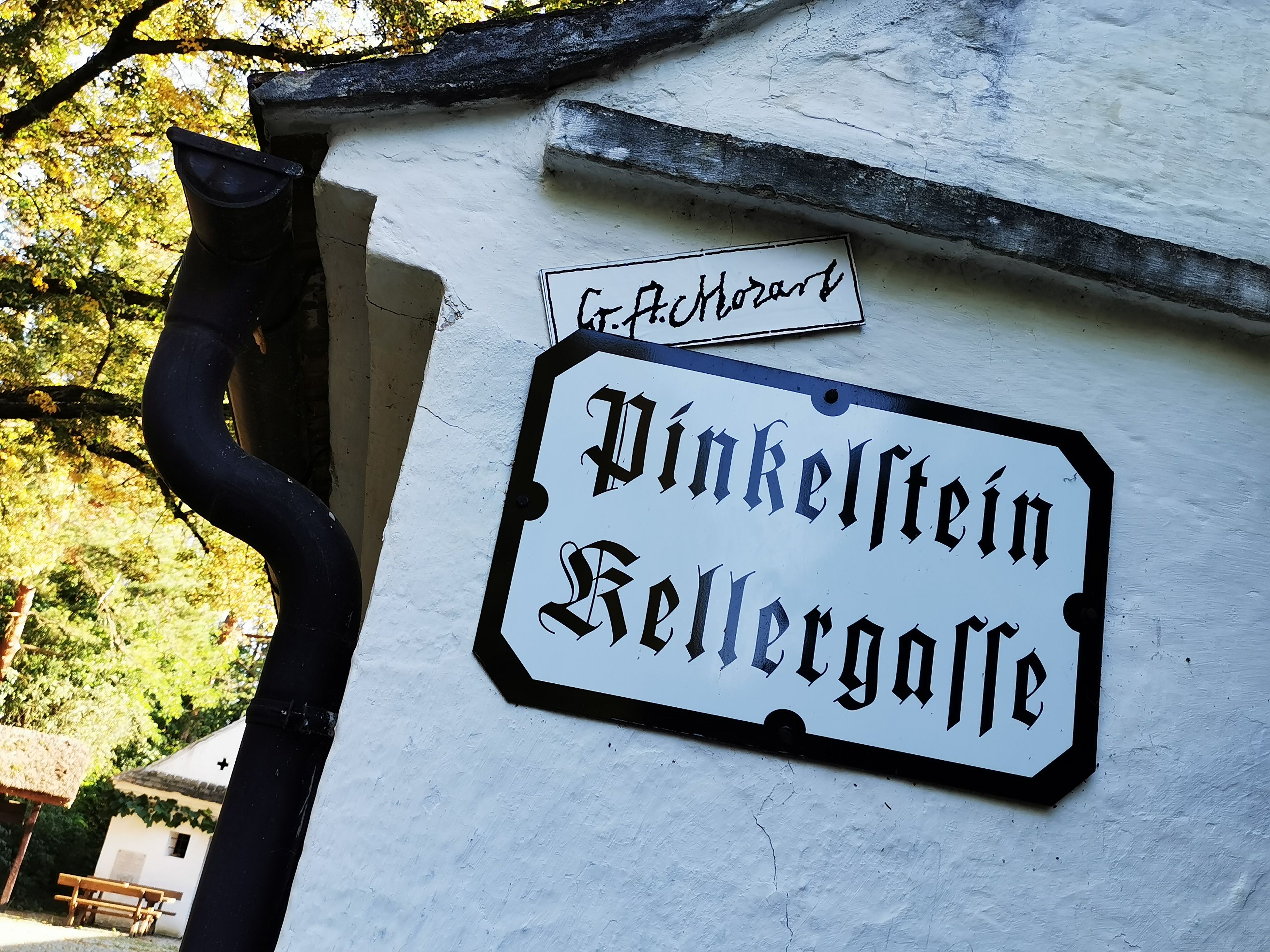 Tabuľa s nápisom "Pinkelstein Vínne uličky" na bielej stene.