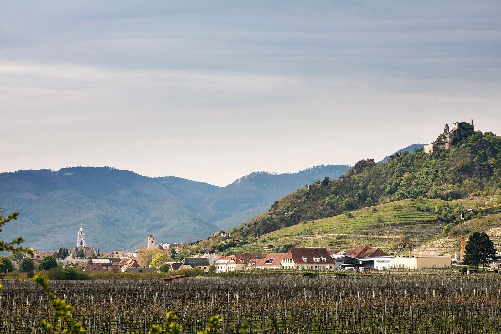 Pohľad na zrúcaninu Dürnstein a okolitú krajinu s vinicami a dedinou.