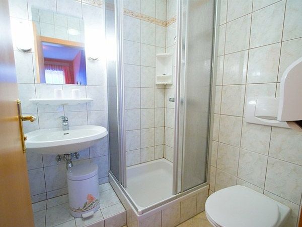 Malá kúpeľňa so sprchovacím kútom, umývadlom a WC.