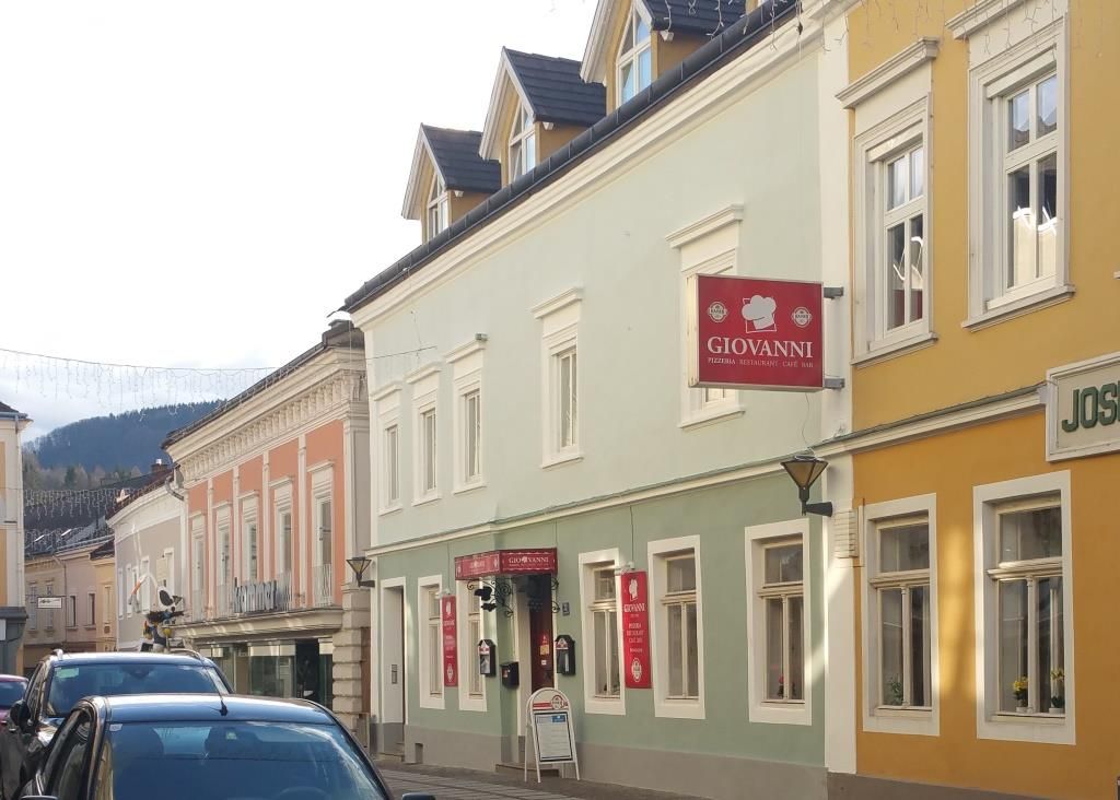 Scéna ulice s farebnými budovami a nápisom "Giovanni".