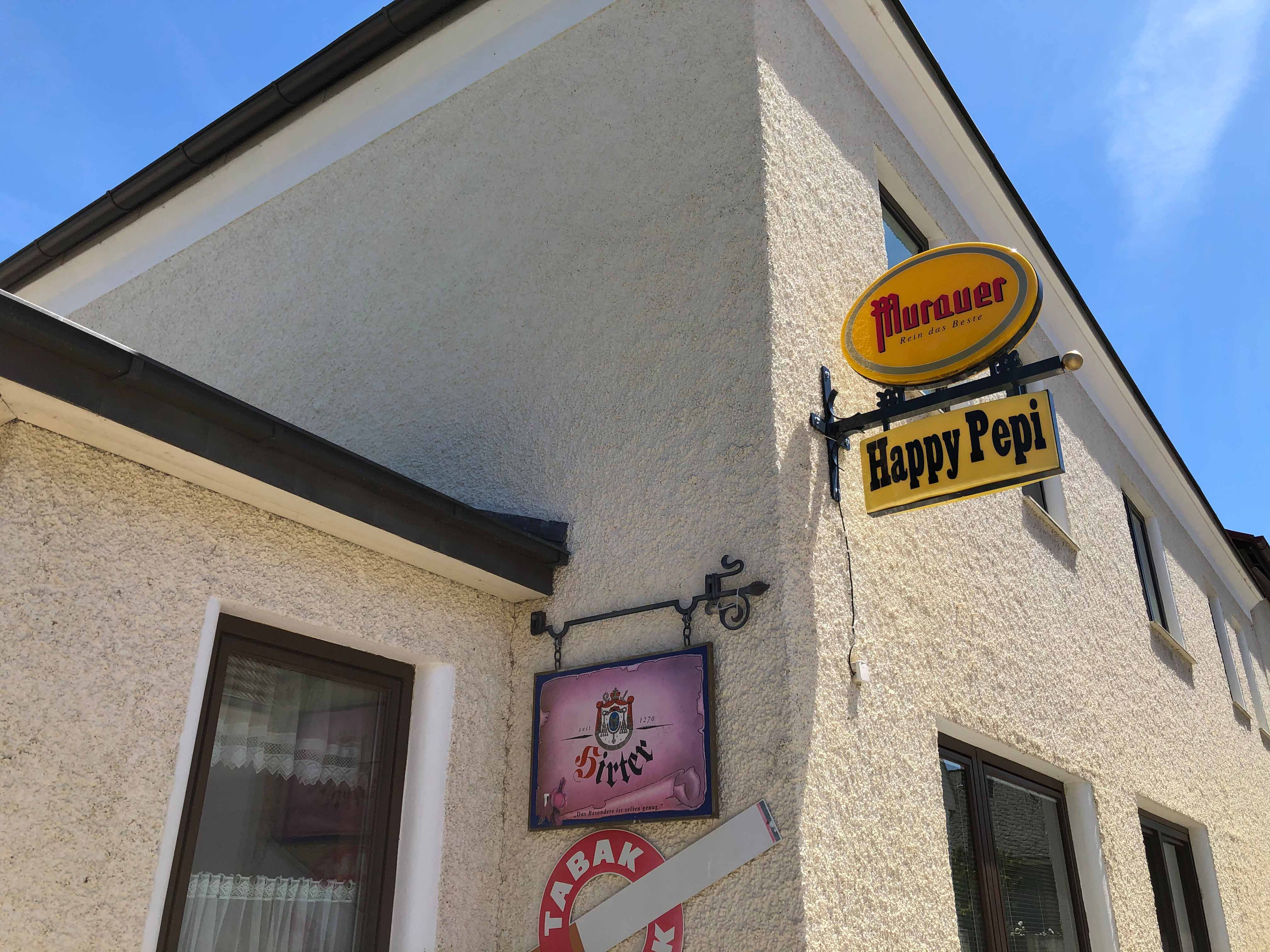 Vonkajší pohľad na budovu s nápismi "Murauer" a "Happy Pepi".