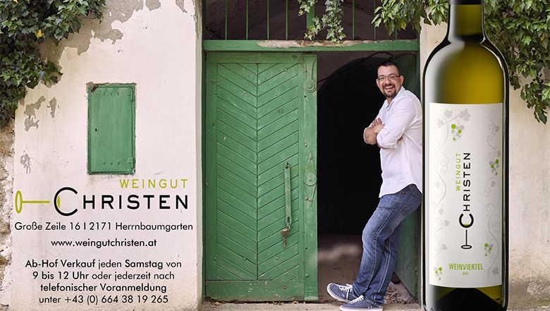 Muž sa opiera o zelené dvere vedľa fľaše vína s nápisom "Weingut Christen".