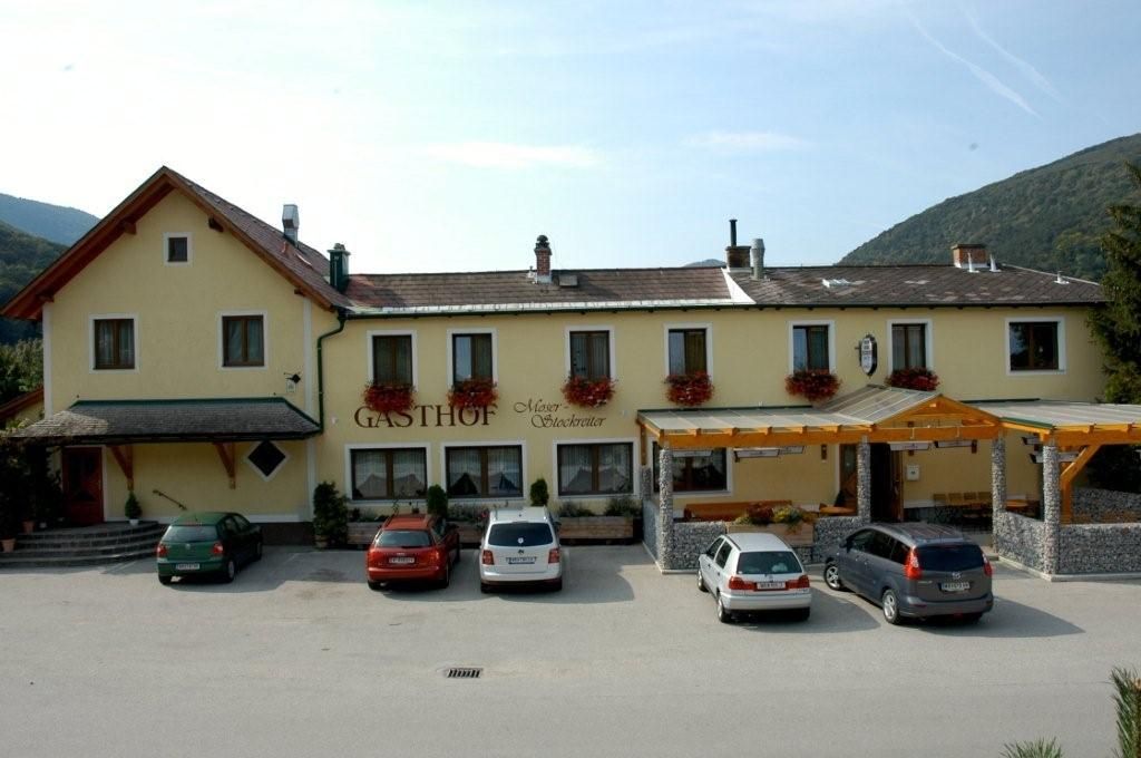 Gasthof Moser-Stockreiter so zaparkovanými autami pred ním.
