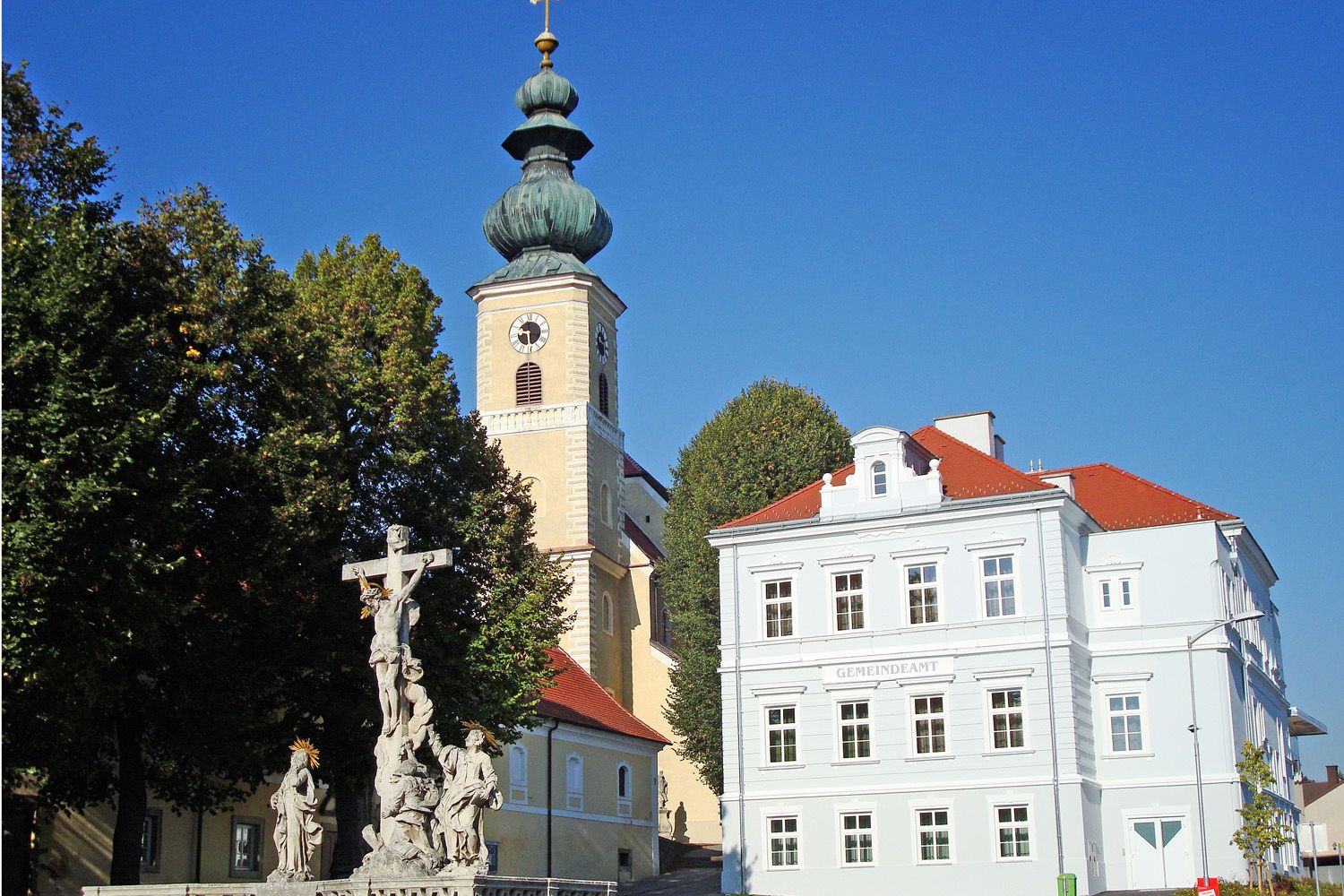 Kostol s cibuľovou kupolou a farským úradom v rakúskom Gaweinstale.