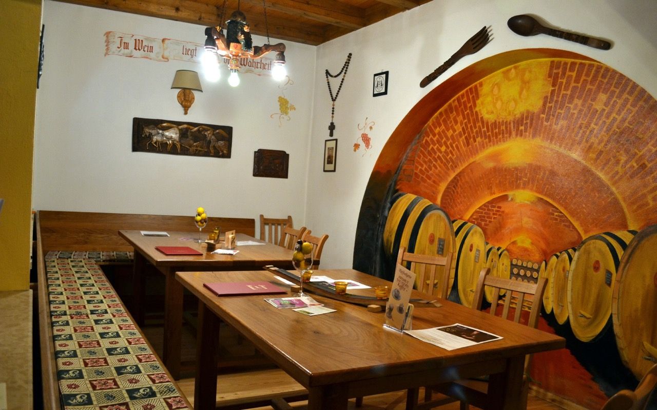 Útulný salónik Lössiade s drevenými stolmi, teplým osvetlením a tradičným nábytkom.