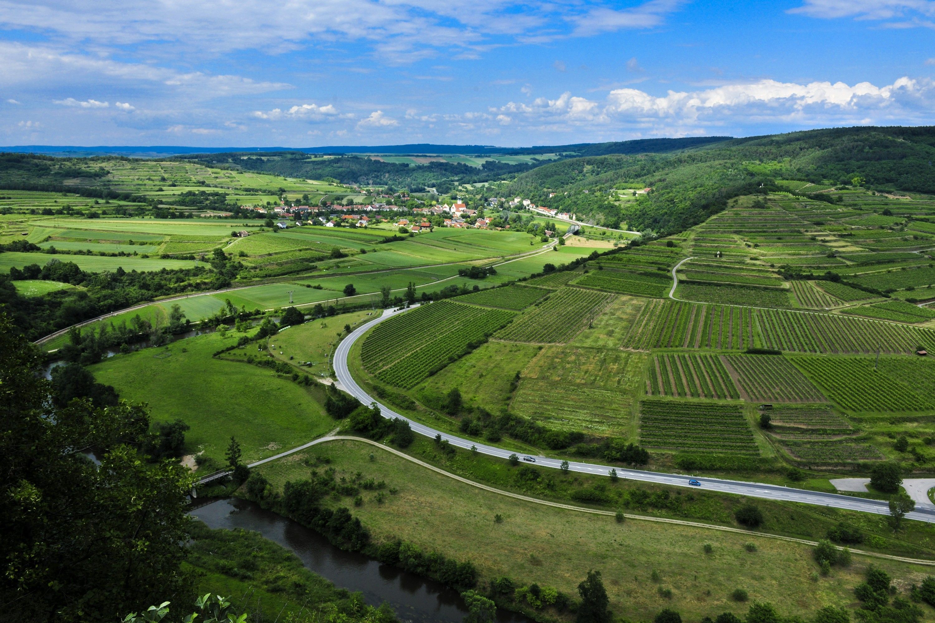 Krajina v prírodnom parku Kamptal Schönberg s poliami, cestami a riekou.