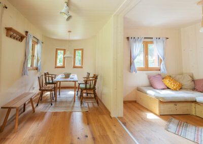 Pohľad do interiéru útulného modulárneho domu s jedálenským kútom a obývacím priestorom.