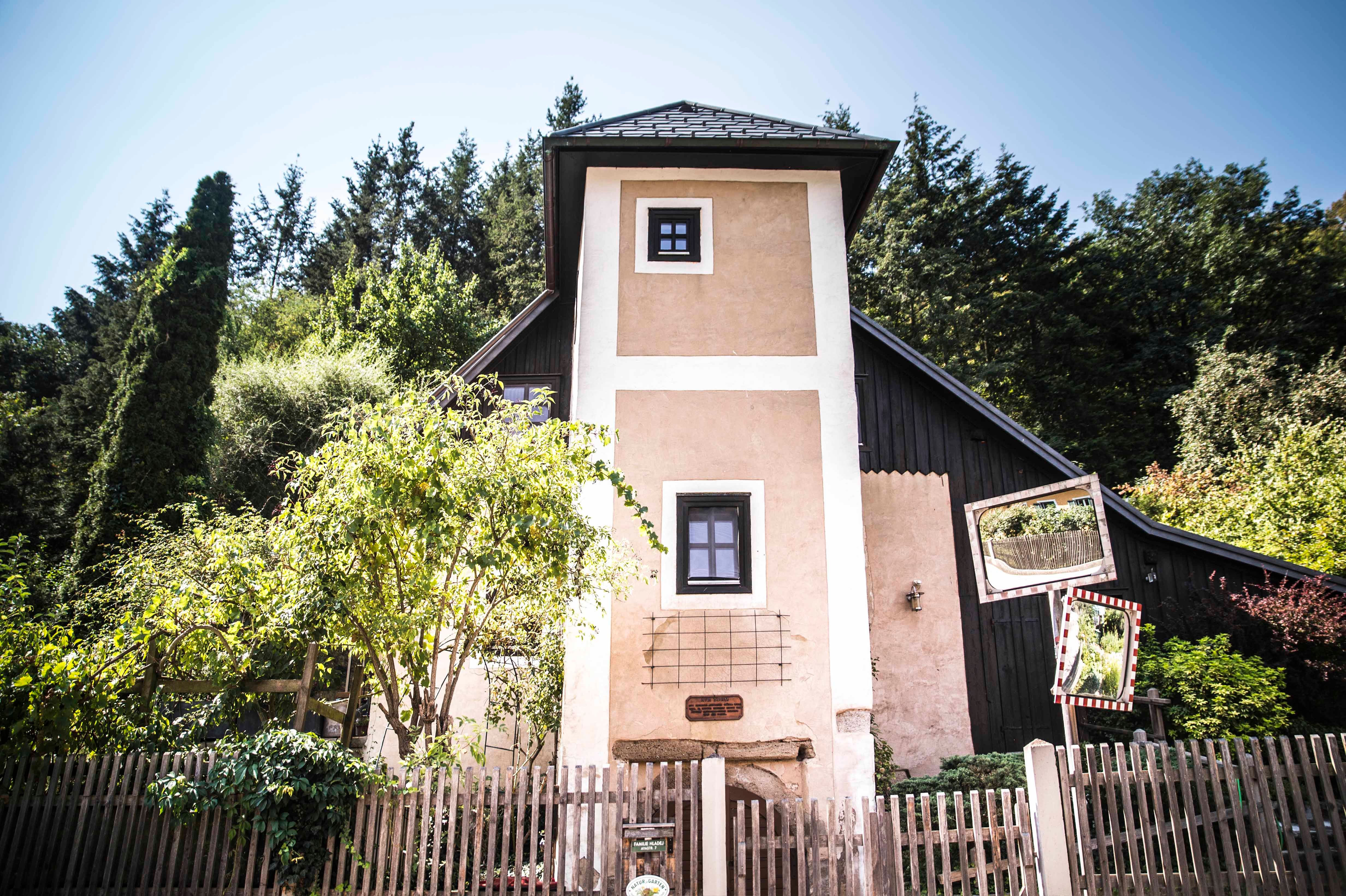 Malá veža s dreveným plotom a stromami v pozadí.