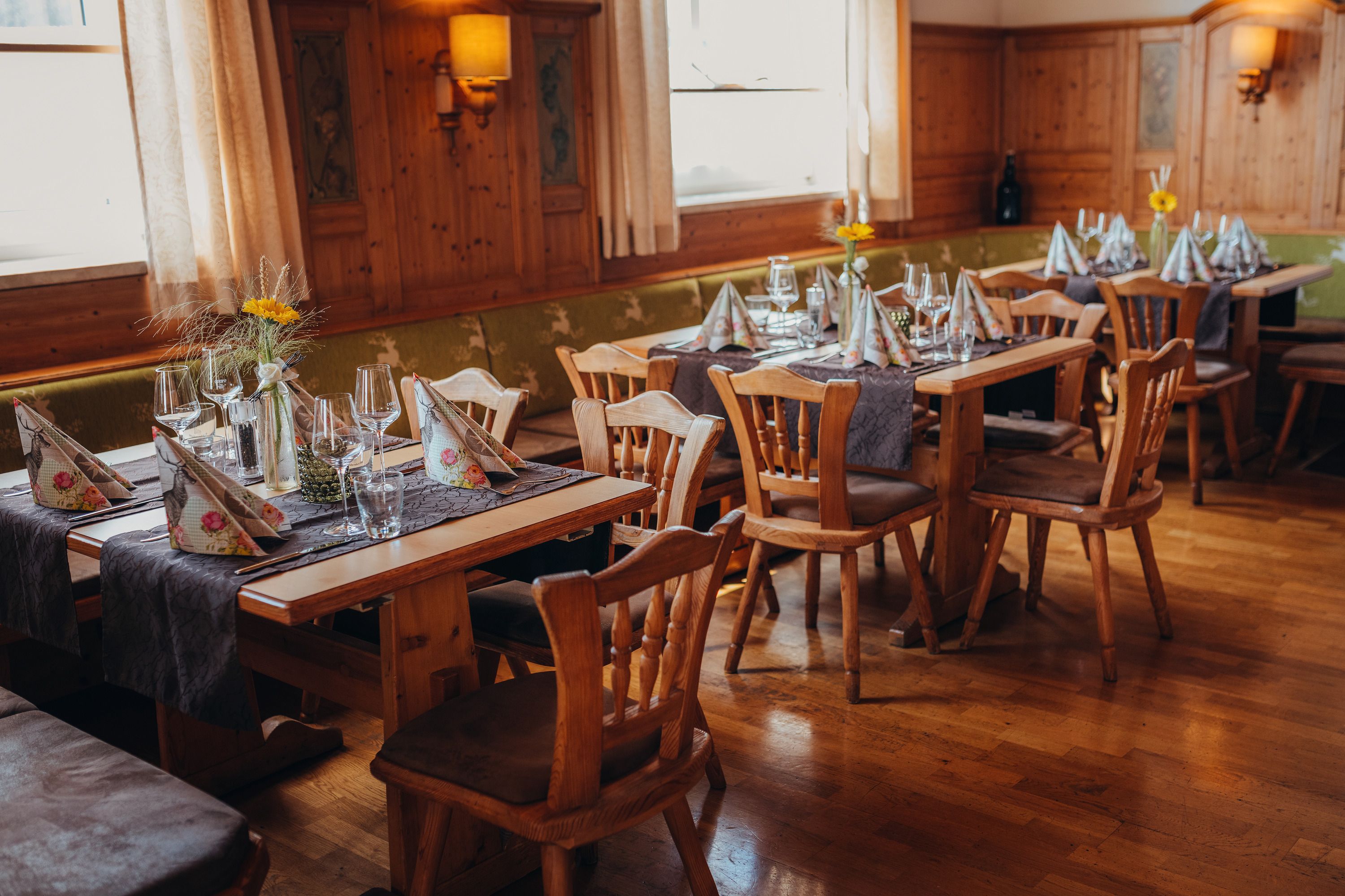 Útulná reštaurácia s dreveným nábytkom a prestretými stolmi.