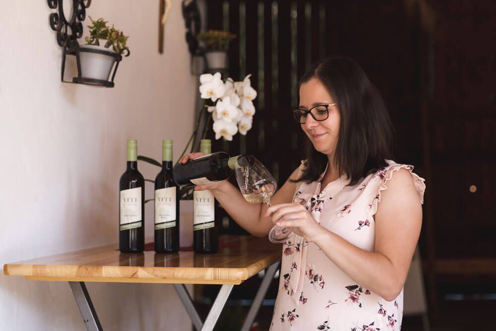 Žena nalieva víno do pohára.