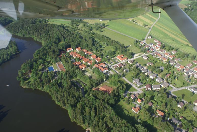 Letecký pohľad na golfové ihrisko a jazero so susedným sídliskom.