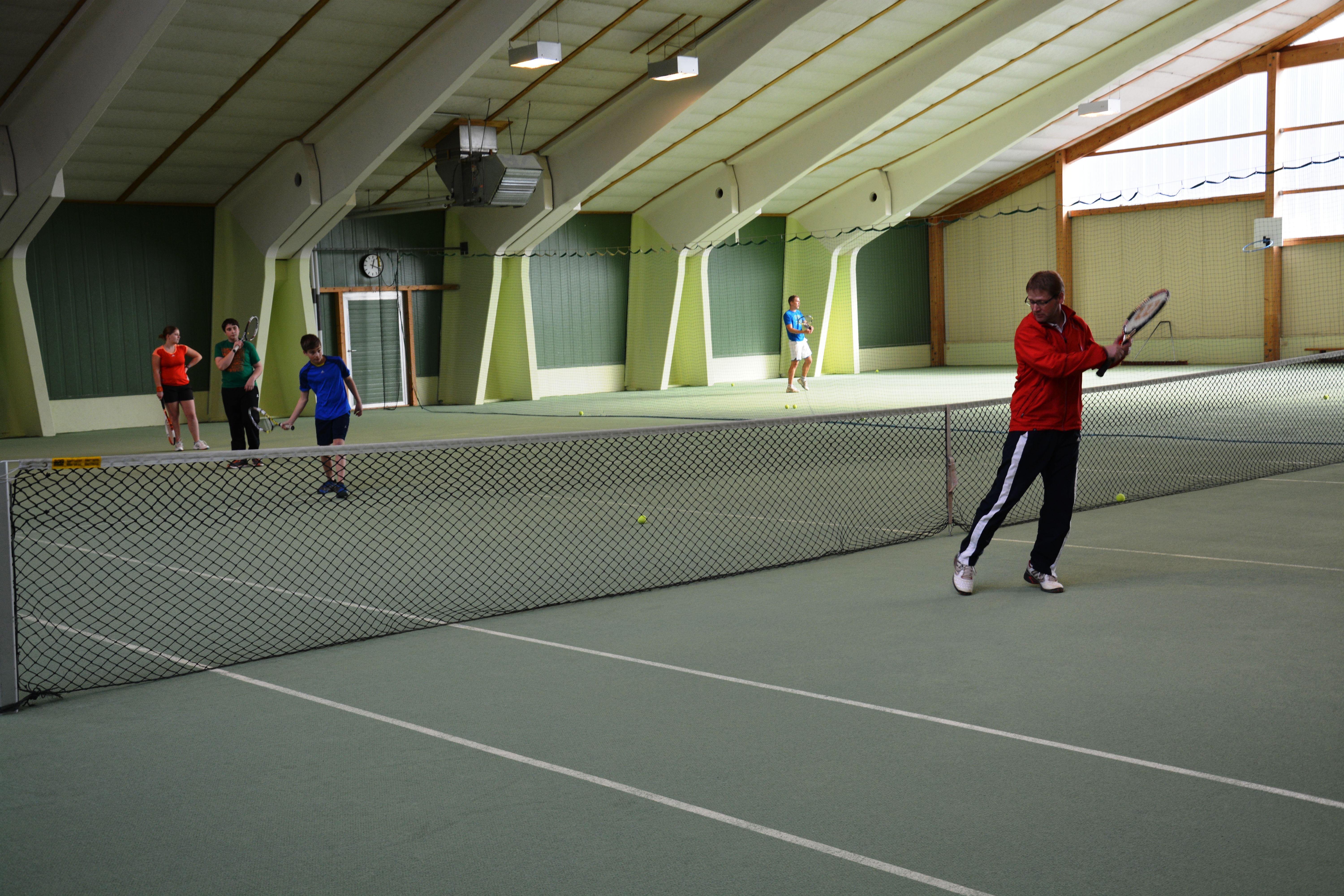 Ľudia hrajú tenis v krytom tenisovom centre.