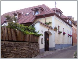 Tradičný dom s červenými škridlami a kvetmi na oknách.