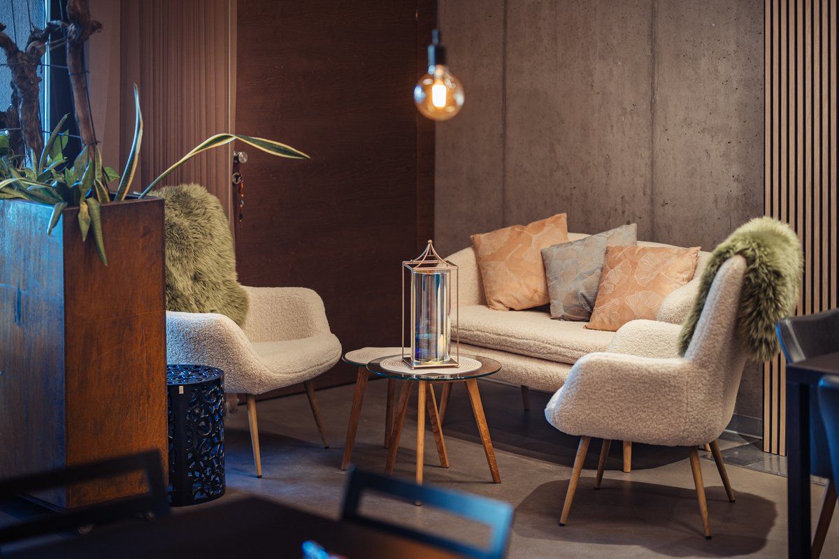 Útulný priestor na posedenie s pohovkou, kreslami a vankúšmi.