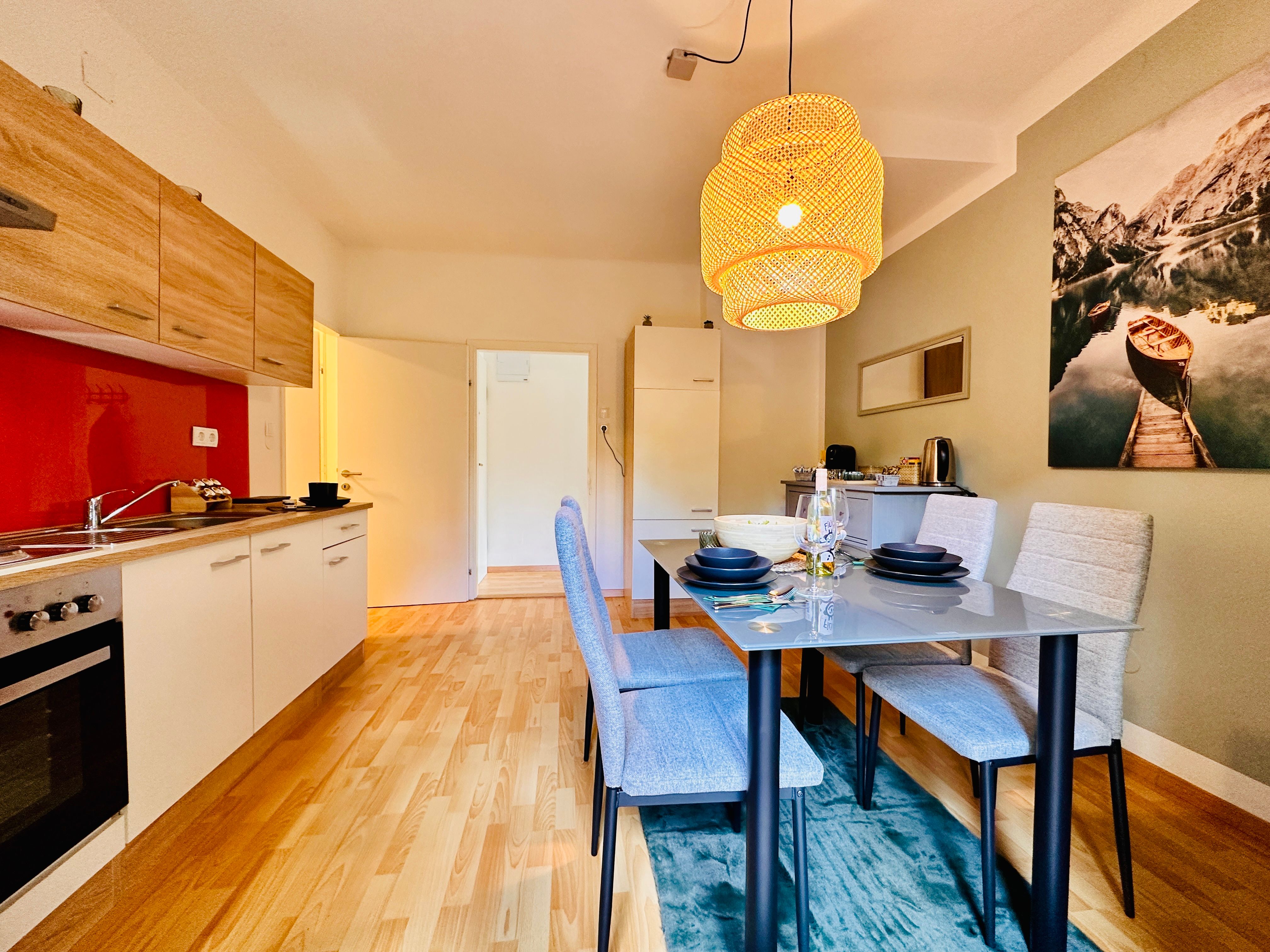 Moderná kuchyňa s jedálenským stolom a závesnou lampou.