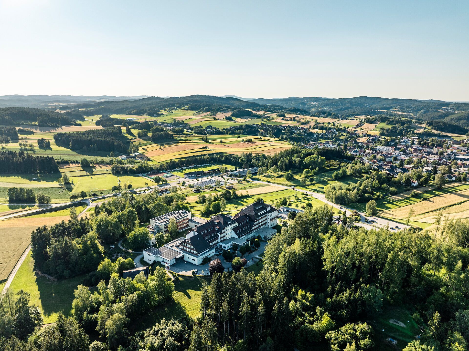 Letecký pohľad na kardiovaskulárne centrum Groß Gerungs vo Waldvierteli, obklopené lúkami, poľami, lesom a obcou Groß Gerungs.