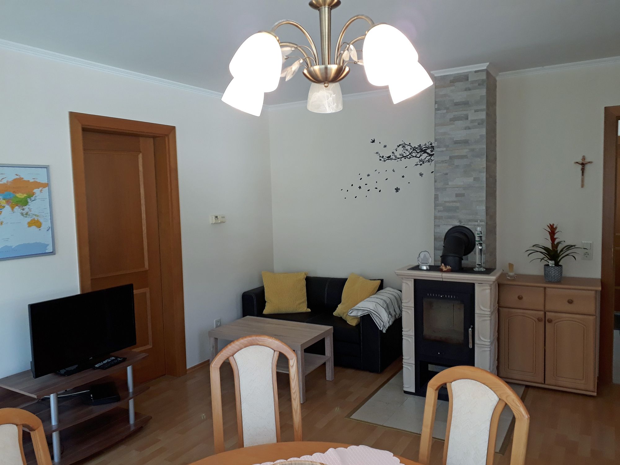 Obývacia izba s krbom, pohovkou, stolom a TV.