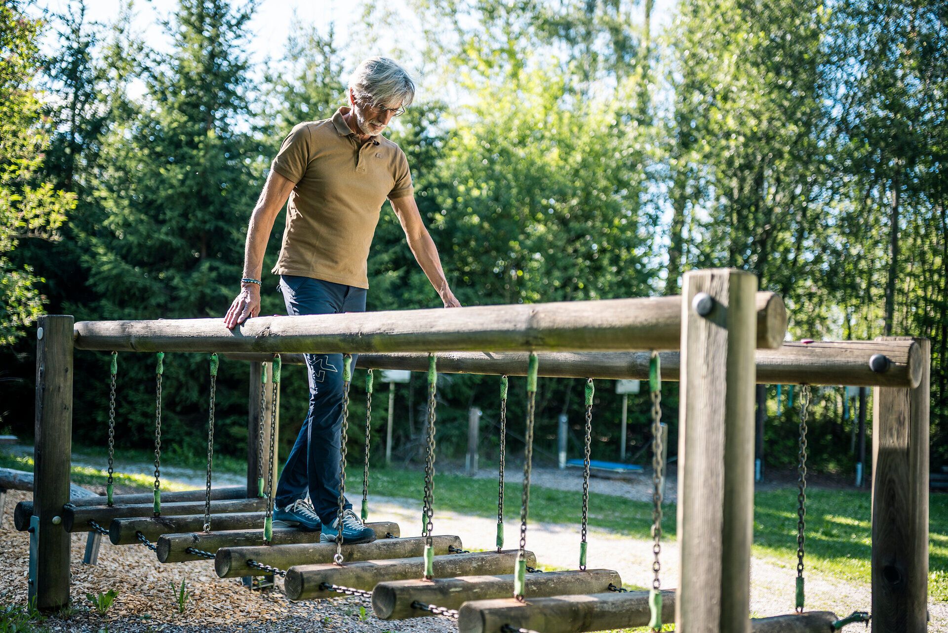 Muž balansuje na drevenej prekážkovej dráhe pri Kardiovaskulárnom centre Groß Gerungs vo Waldvierteli.
