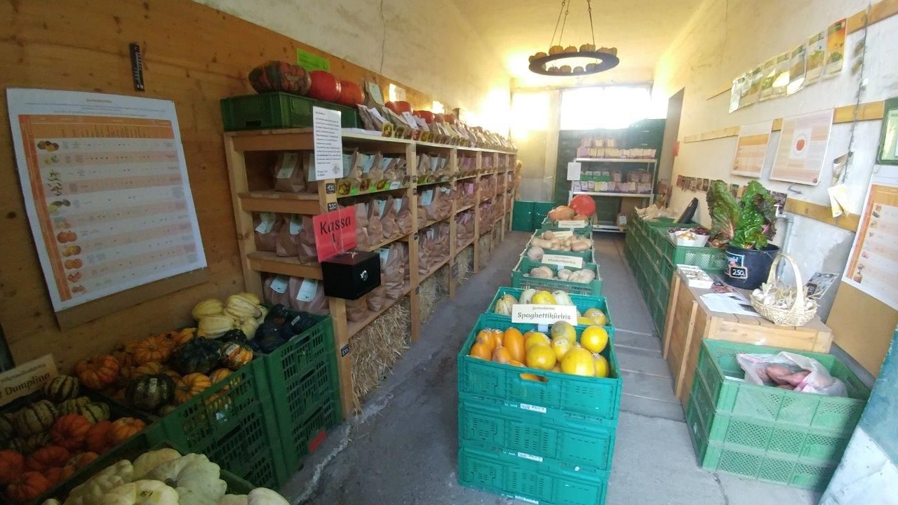 Malý farmársky obchod s regálmi plnými zeleniny a produktov.