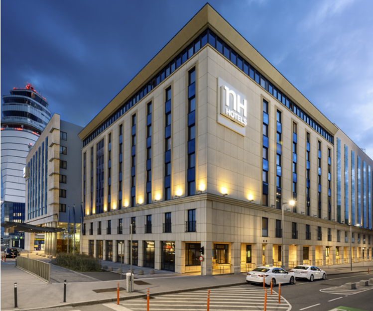 Konferenčné centrum NH Vienna Airport za súmraku s osvetlenou budovou.