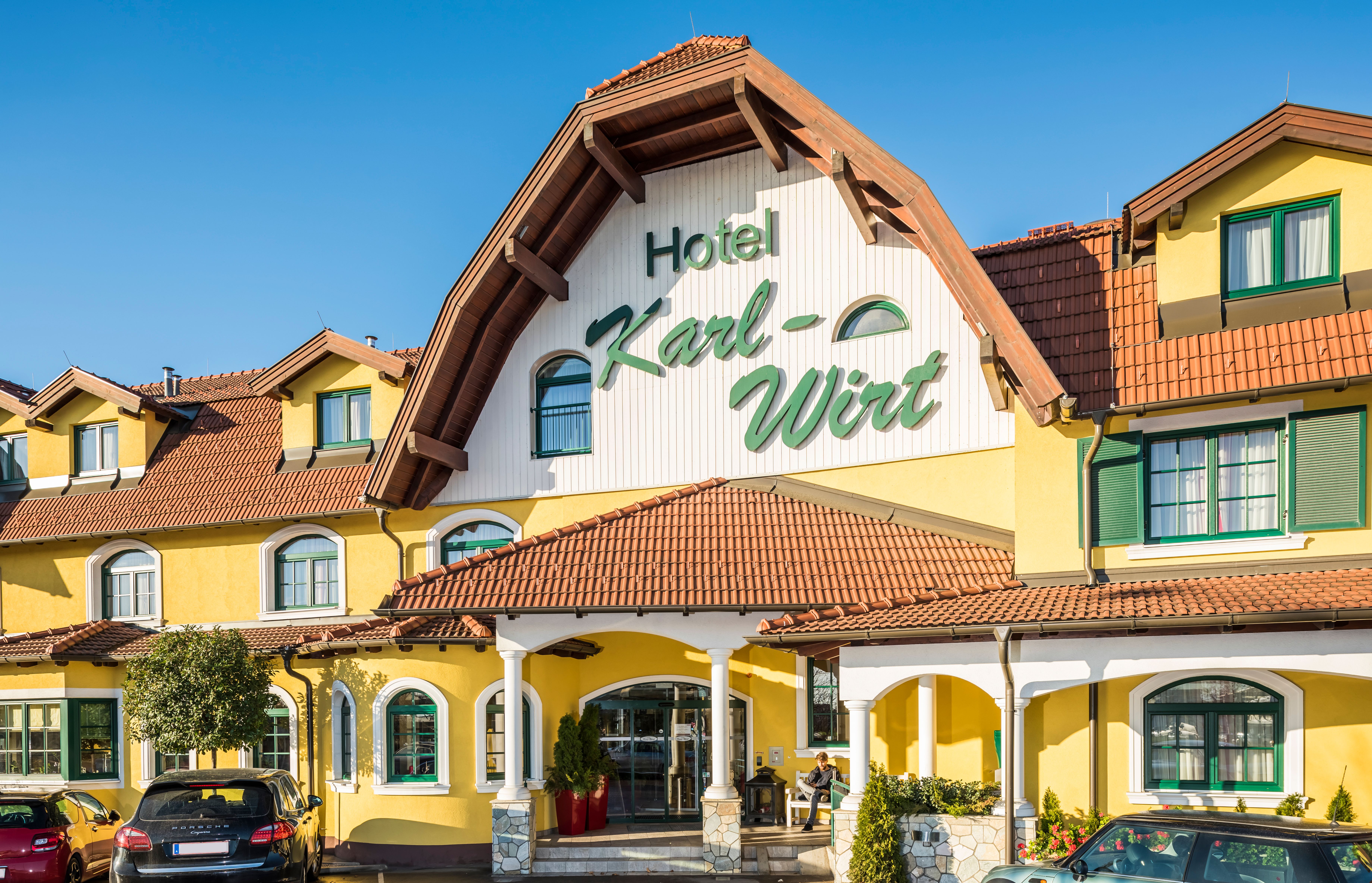 Žltá budova hotela s nápisom "Hotel Karl-Wirt" na štíte.
