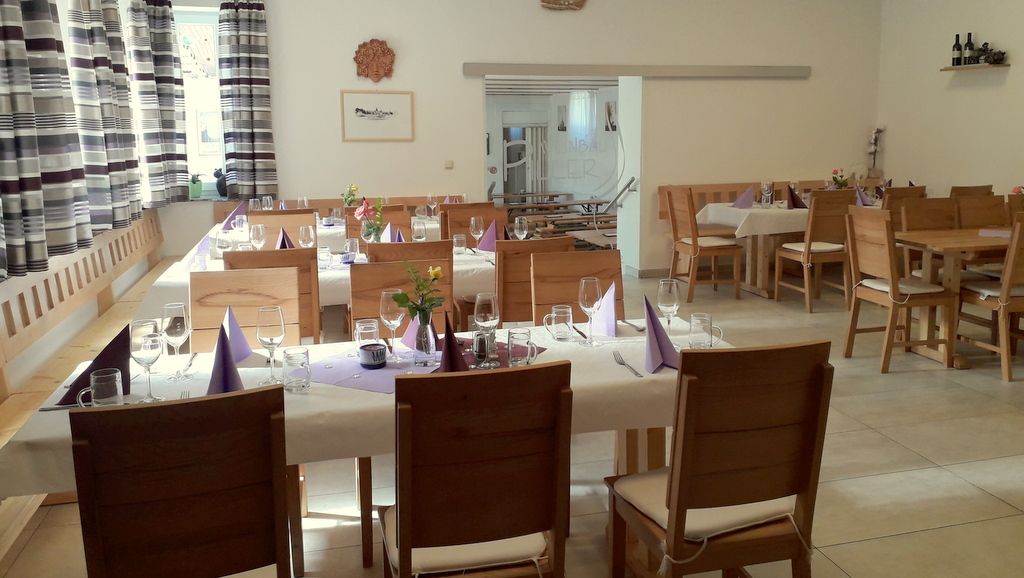 Pohľad do interiéru útulnej vinárne s prestretými stolmi a dreveným nábytkom.