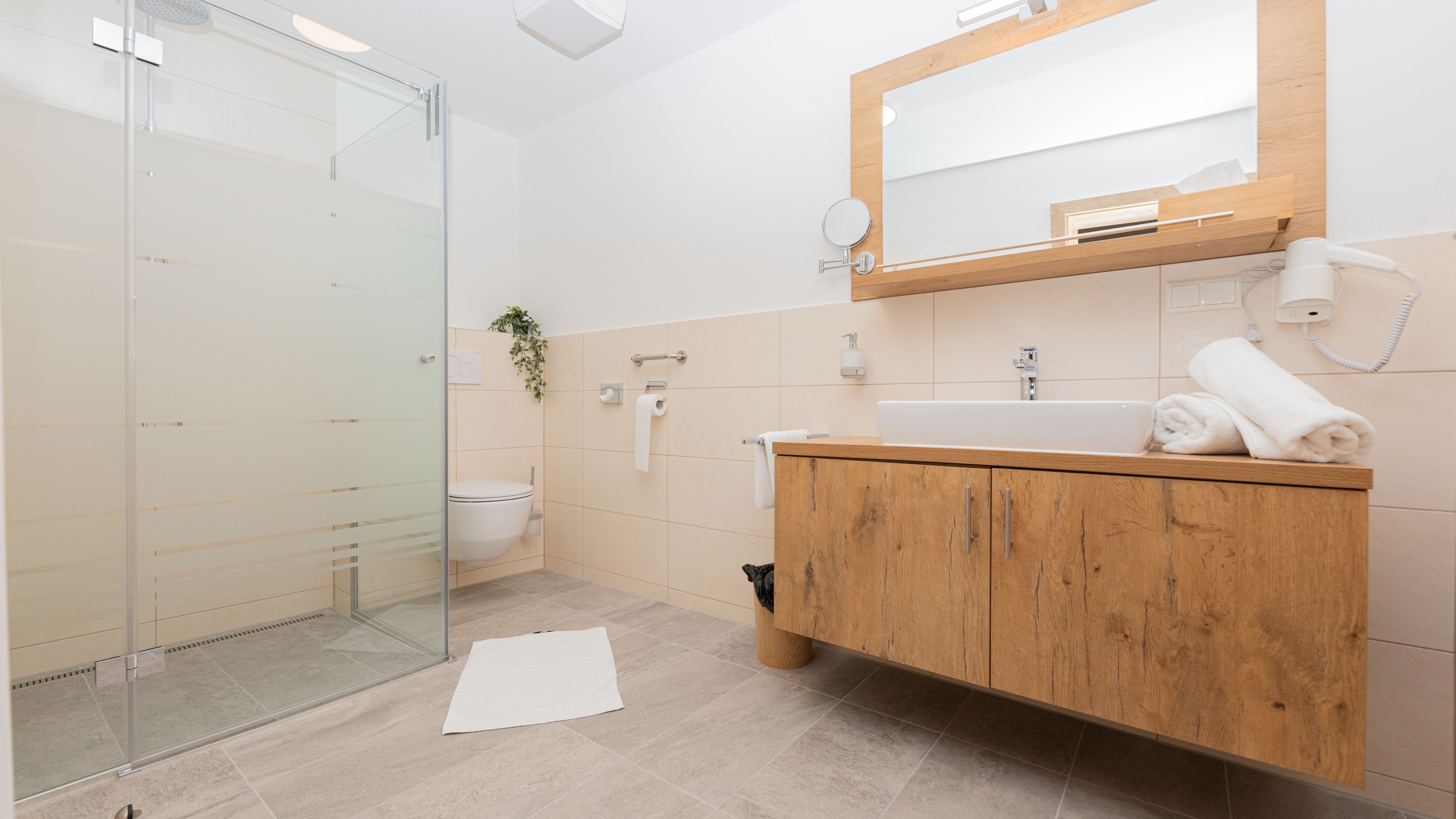 Moderná kúpeľňa so sprchovacím kútom, umývadlom a WC.