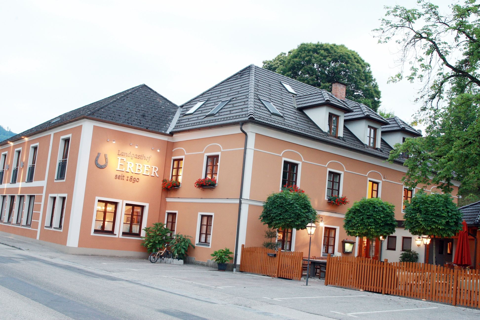 Vonkajší pohľad na Landgasthof Erber s oranžovou fasádou a kvetinovými truhlíky.