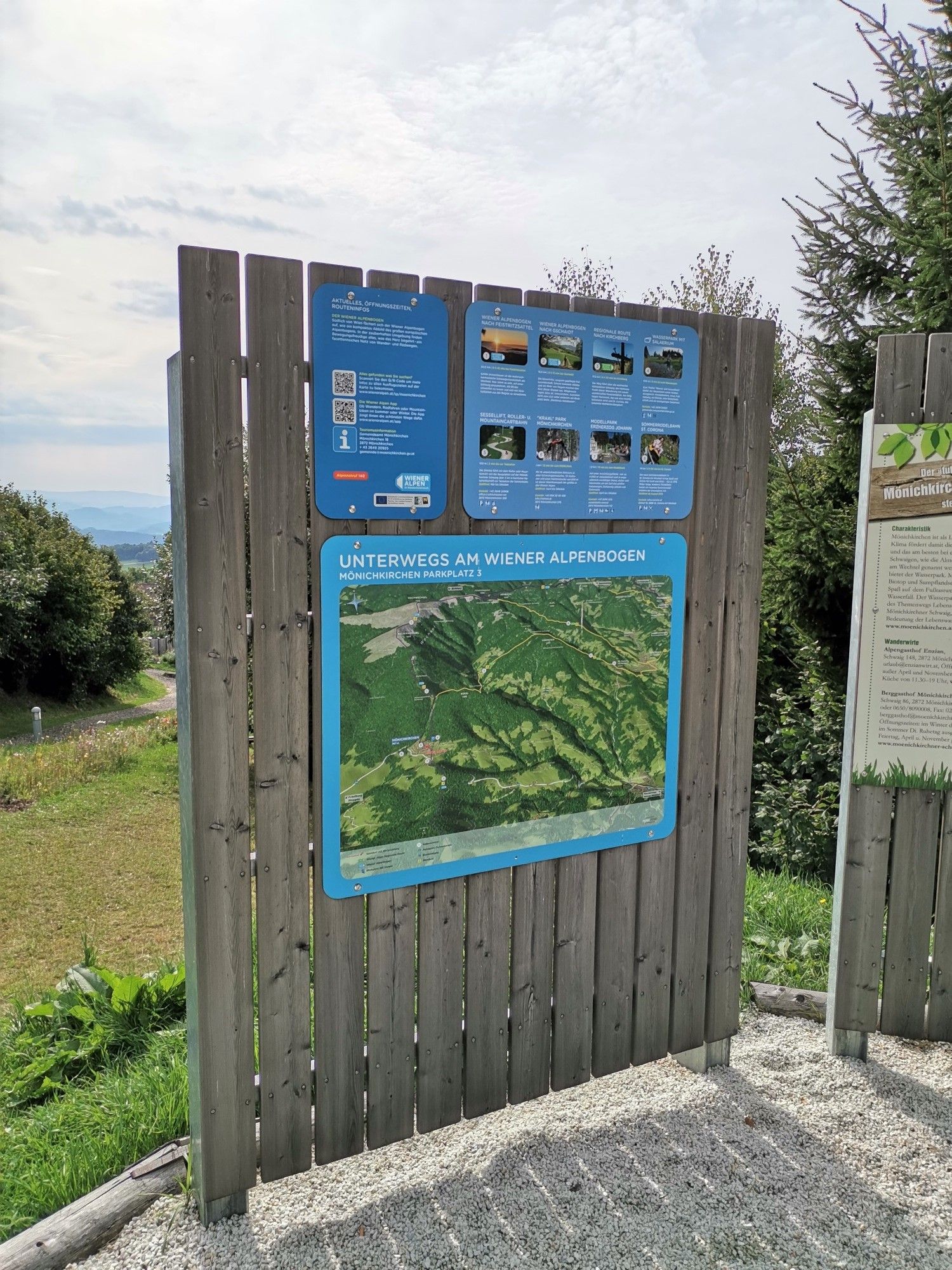Informačná tabuľa pri oblúku Viedenských Álp (diaľková turistická trasa) s mapou a textami.