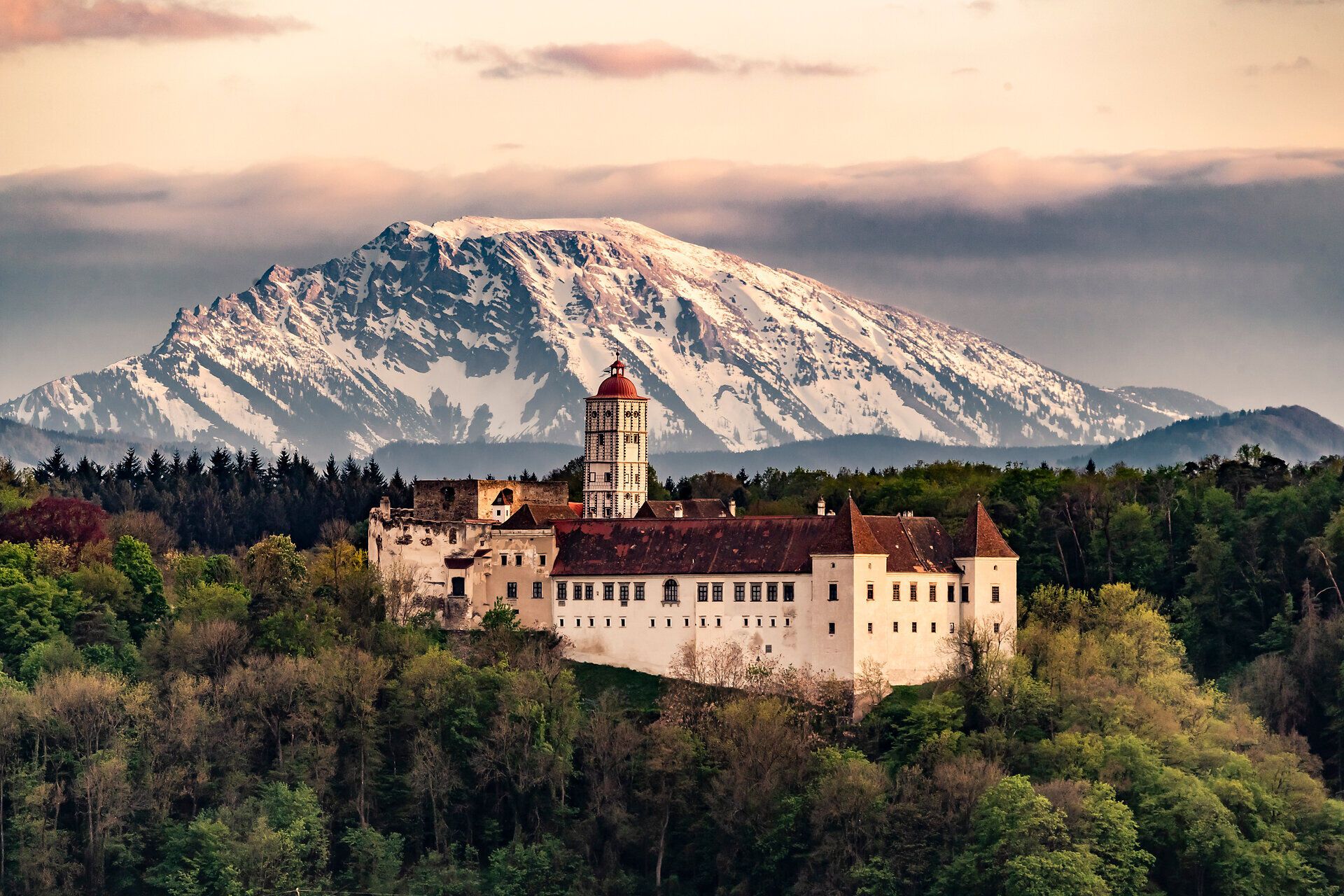 Die majestätische Schallaburg erhebt sich stolz vor der beeindruckenden Kulisse der schneebedeckten Berge. Im Frühling erblühen die umliegenden Wiesen in einem bunten Farbenmeer, während die sanften Hügel die perfekte Kulisse für entspannte Spaziergänge bieten. Hier vereinen sich Geschichte und Natur zu einem unvergesslichen Erlebnis.