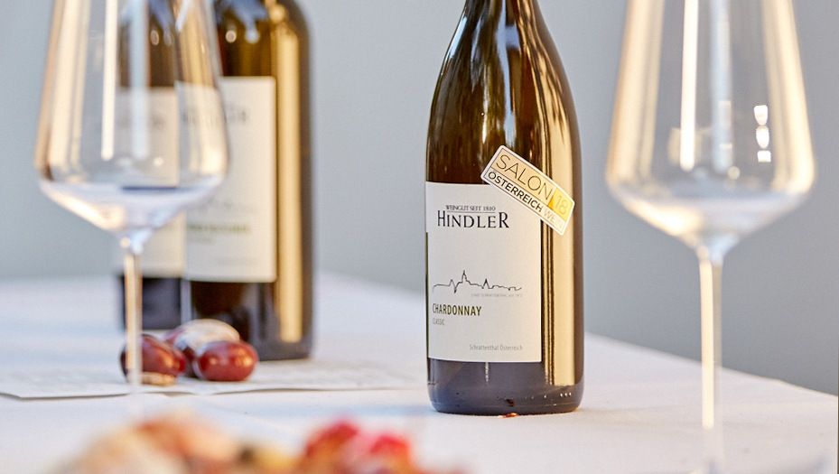 Fľaše a poháre na víno na stole, vinárstvo Hindler.