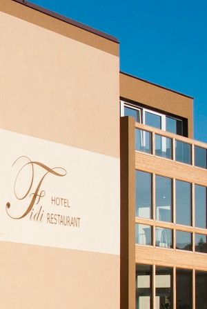Pohľad zvonku na modernú budovu s označením "Fidi Hotel Restaurant".