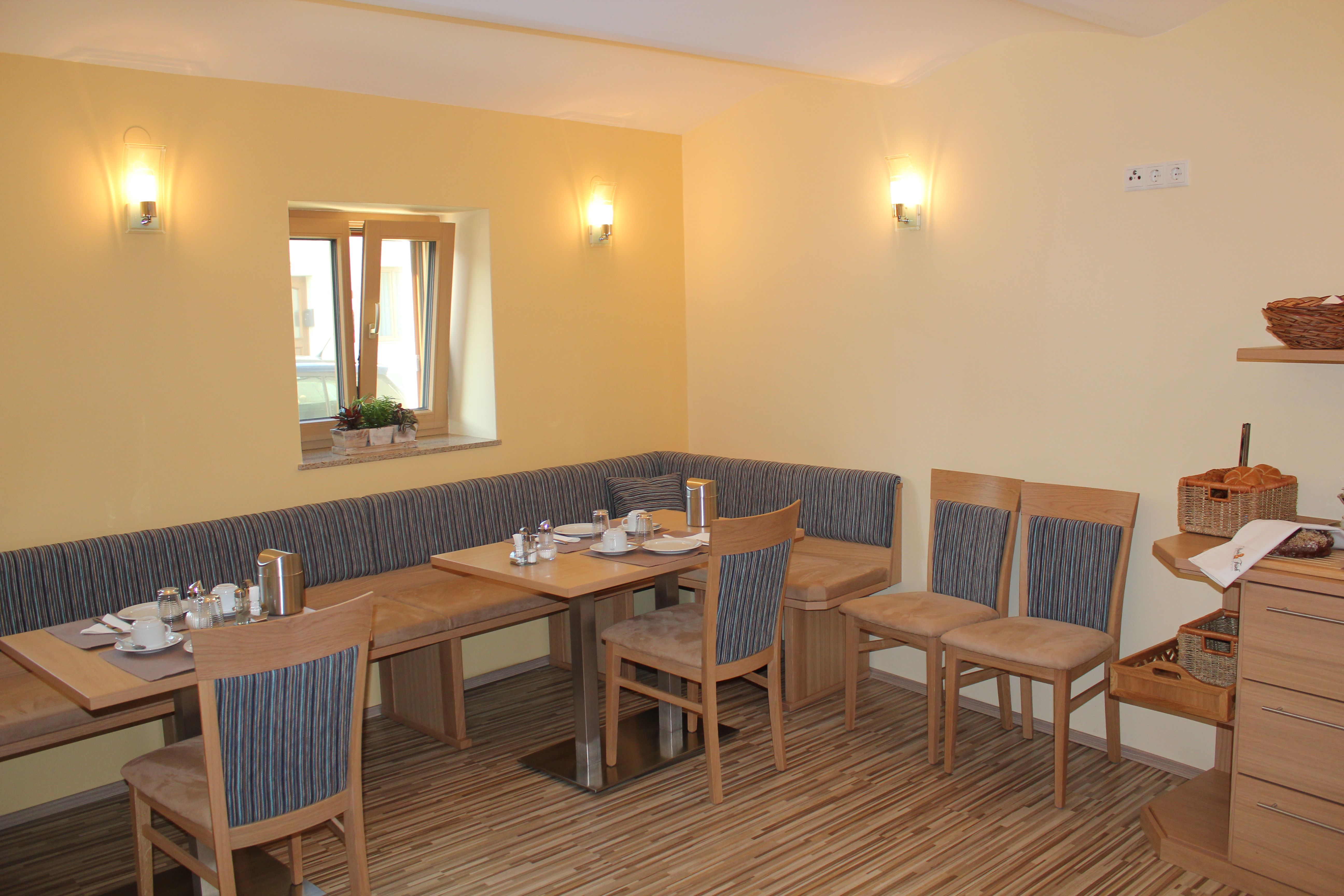 Útulná raňajková miestnosť s dreveným nábytkom a prestretým stolom.