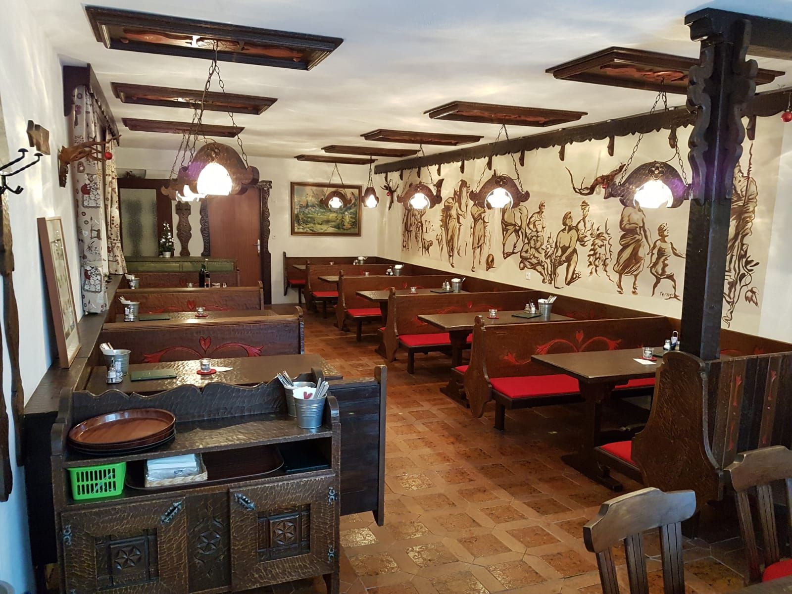 Pohľad do interiéru tradičného vínneho šenku s dreveným nábytkom a nástennými maľbami.