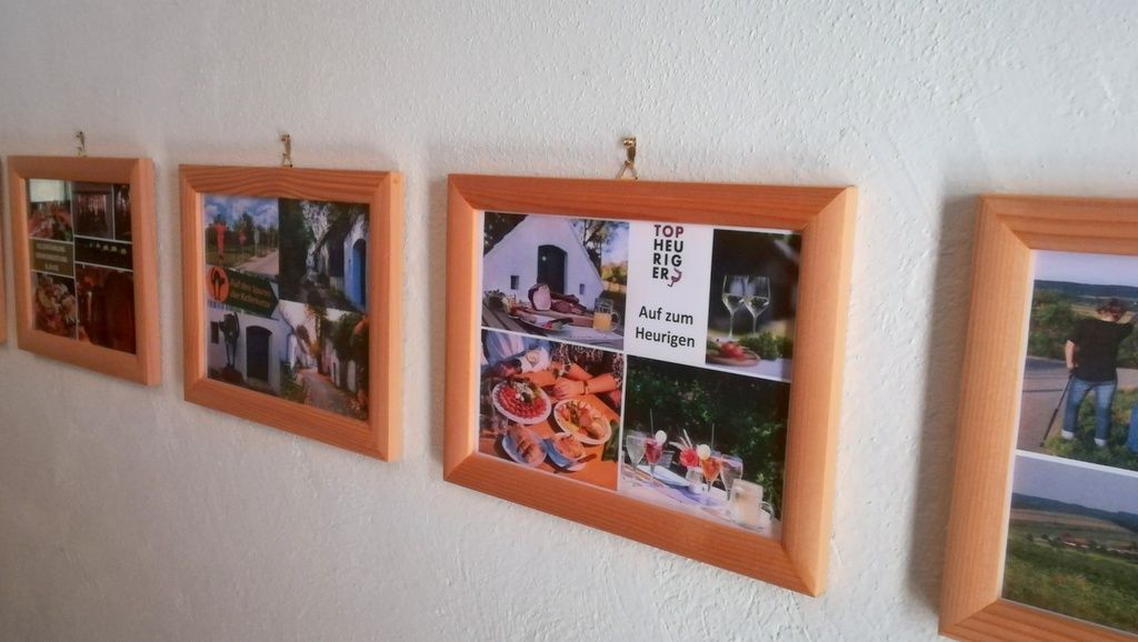 Rad rámov s fotografiami na bielej stene.