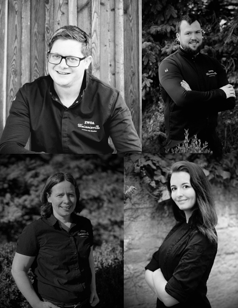 Štyria ľudia na čiernobielych portrétoch, usmievajúci sa a pózujúci v pracovnom oblečení.