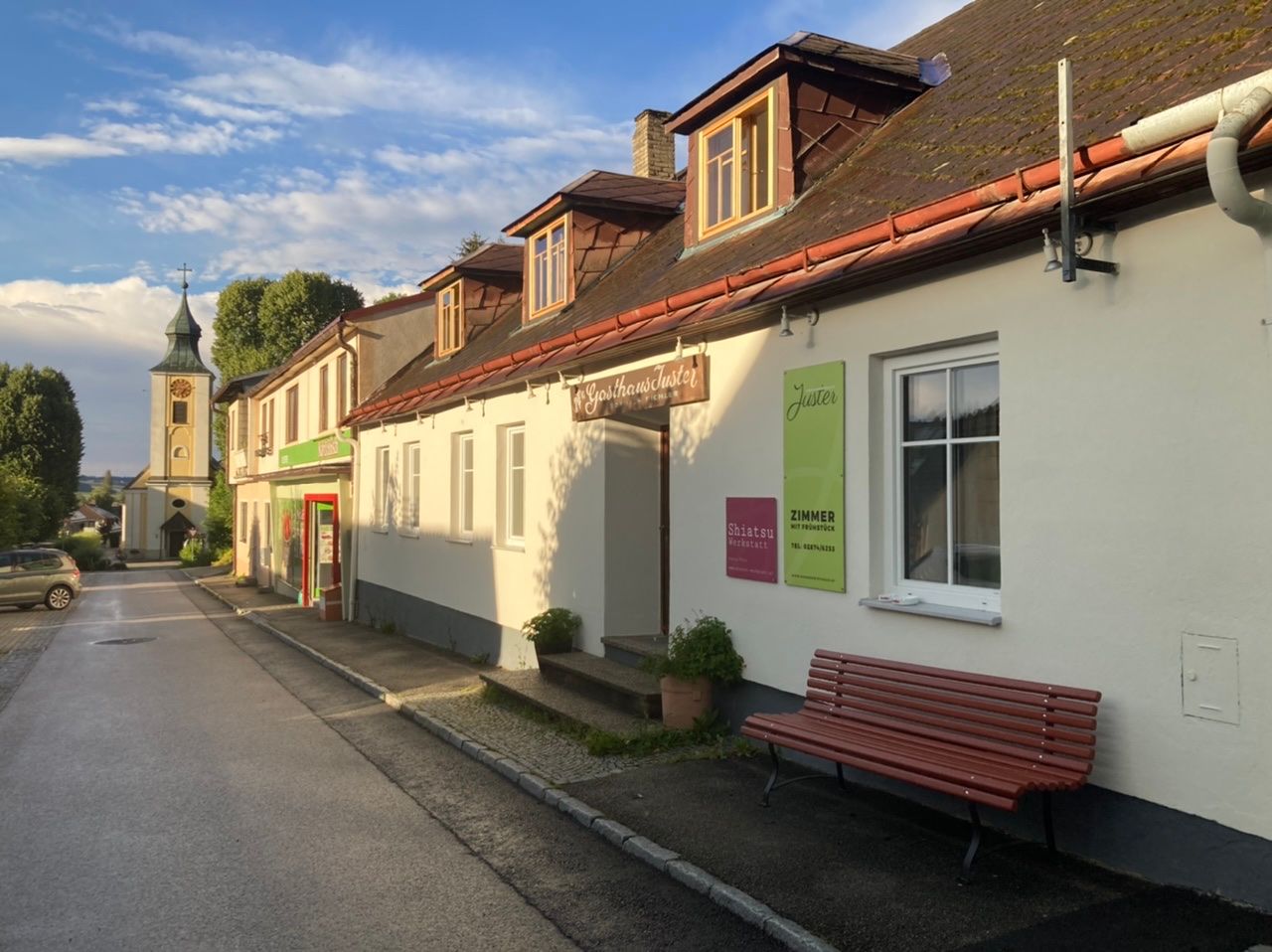 Exteriérový pohľad na hostinec Juster stage s kostolom v pozadí.