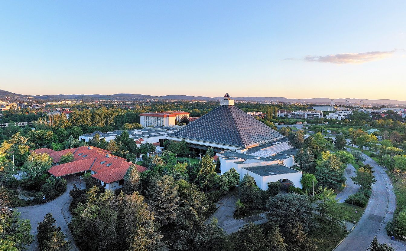 Letecký pohľad na hotel Pyramid s okolitou krajinou a budovami pri západe slnka.