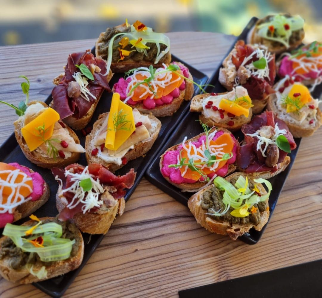 Rôzne sendviče na dvoch čiernych tanieroch.