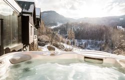 Entspannen Sie im warmen Whirlpool und genießen Sie den atemberaubenden Blick auf die schneebedeckten Berge der Wiener Alpen. Die klare Winterluft und die glitzernde Landschaft schaffen eine magische Atmosphäre, die zum Träumen einlädt.