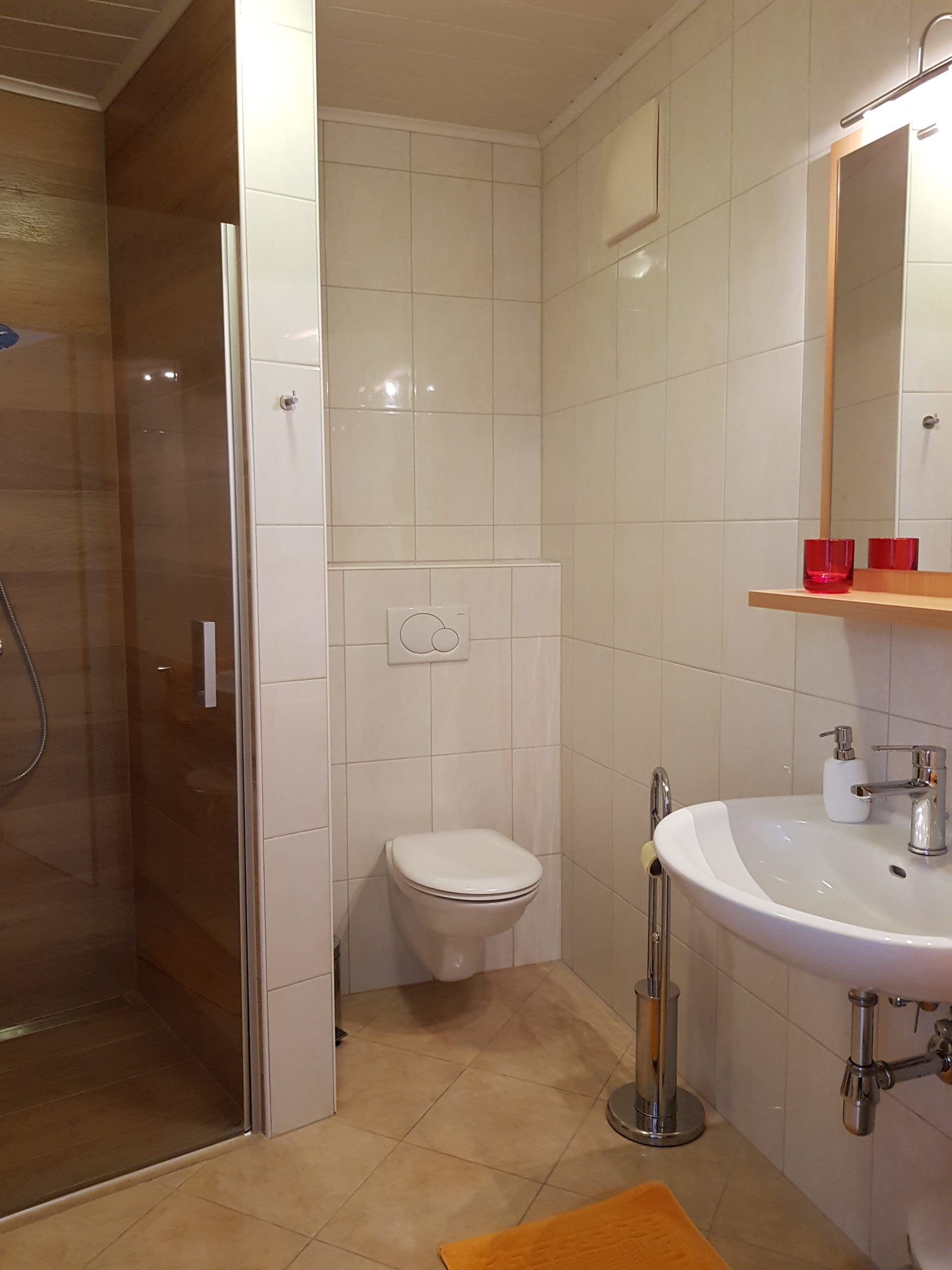 Moderná kúpeľňa so sprchovacím kútom, WC a umývadlom.