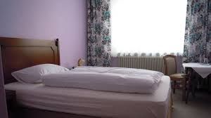 Jednoducho zariadená hotelová izba s posteľou, stolom a stoličkou.