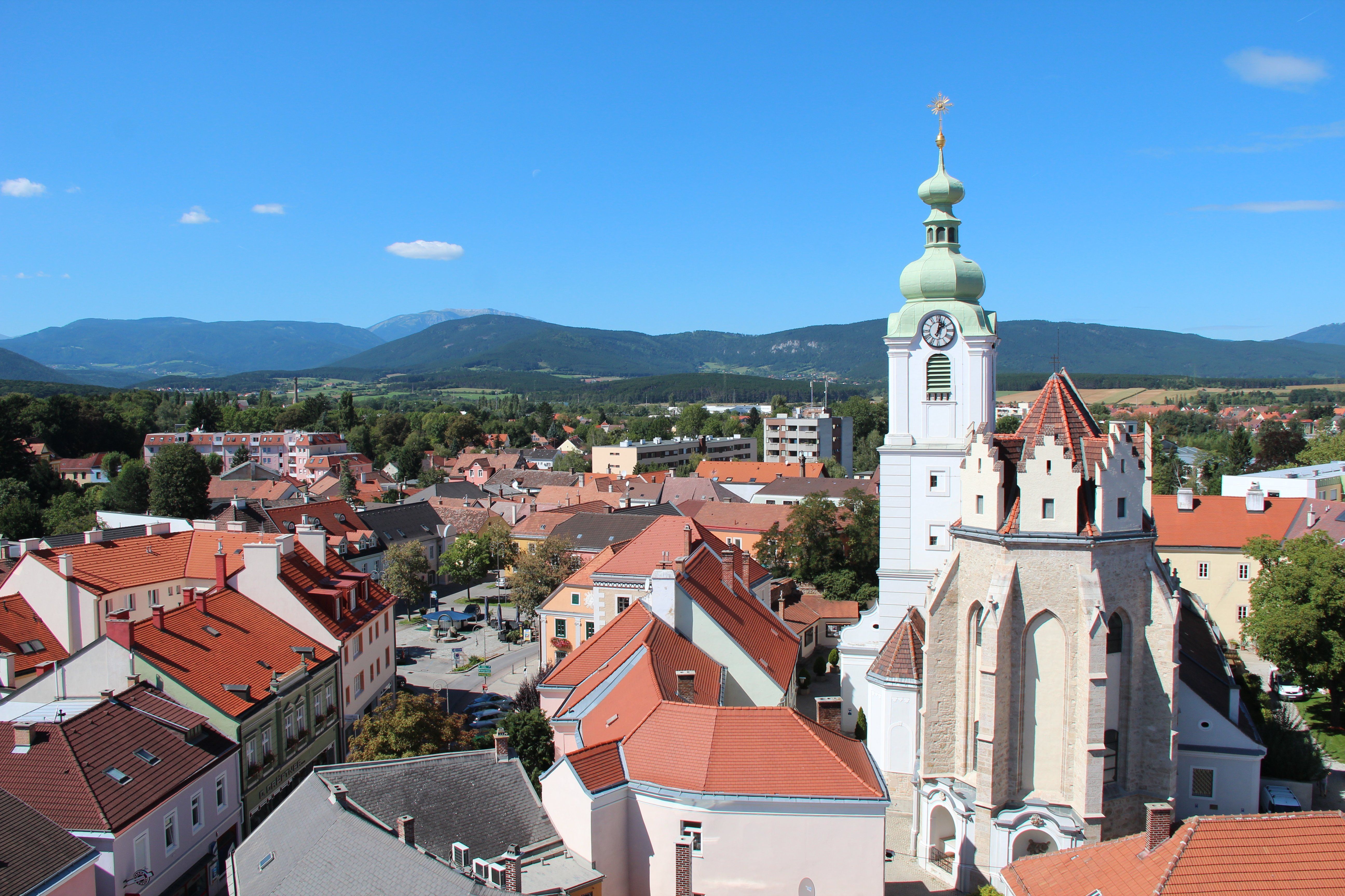 Panoramatický pohľad na Neunkirchen s kostolom a horami v pozadí.