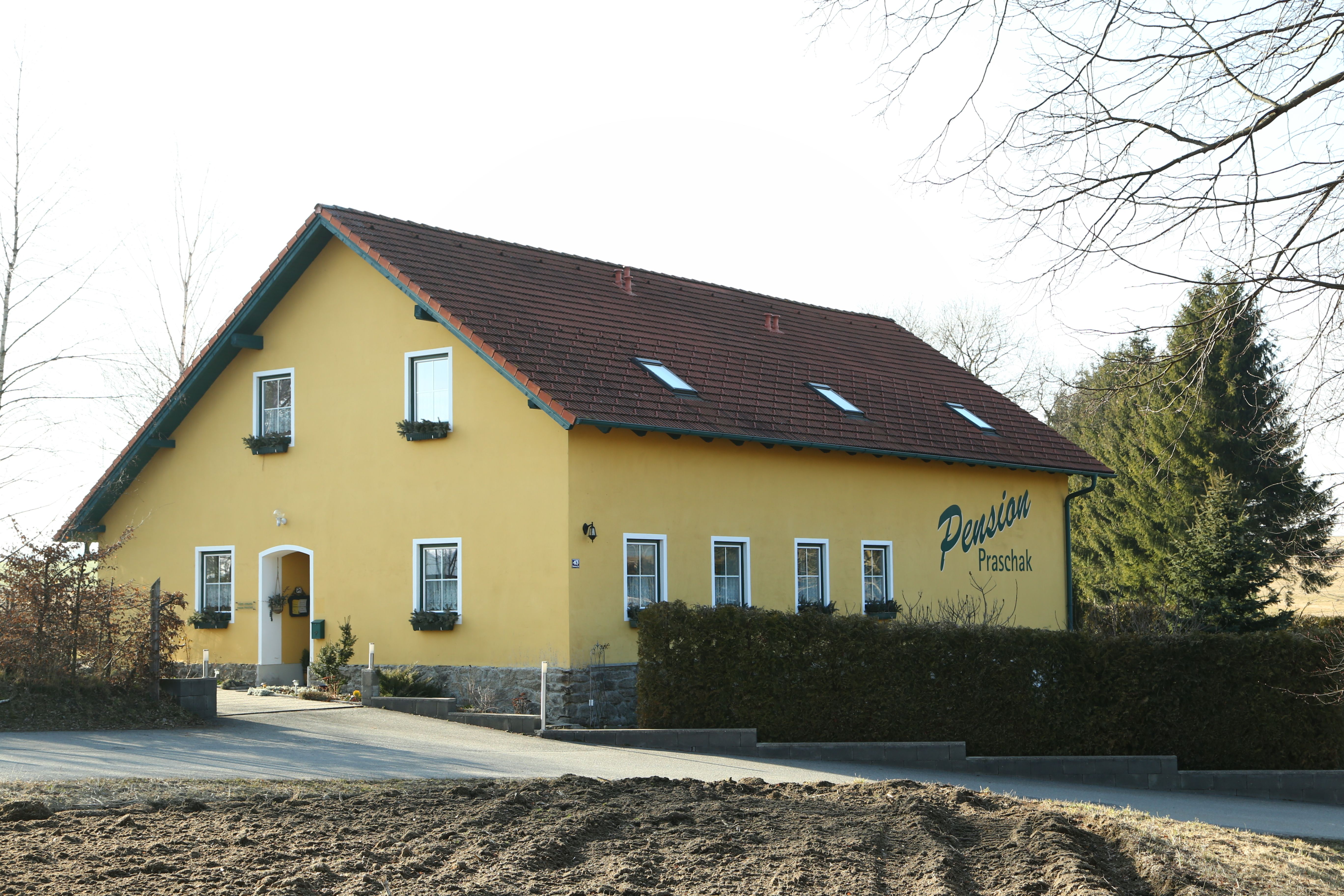 Žltá budova s označením "Pension Praschak".
