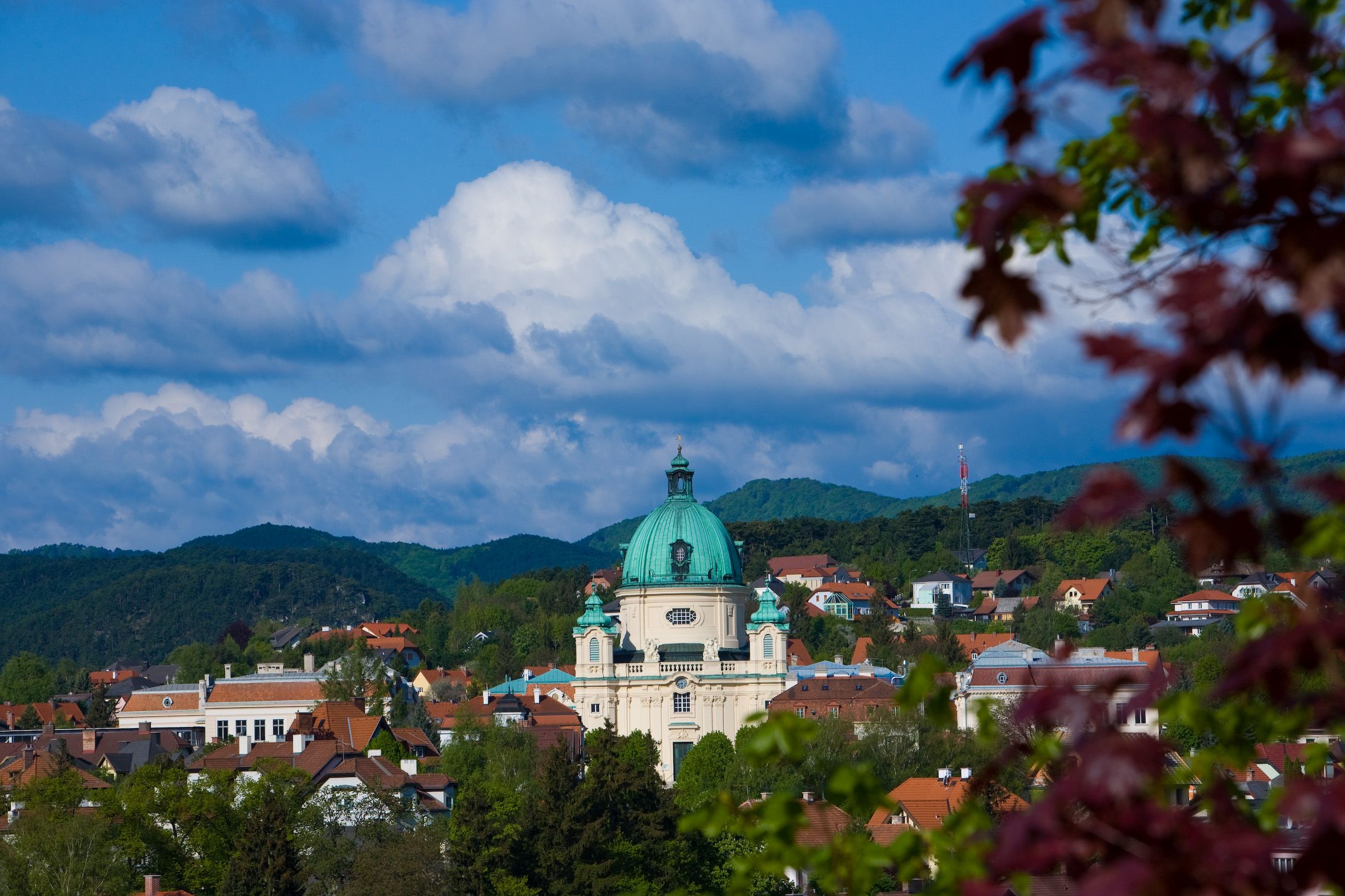 Pohľad na mesto Berndorf s kostolom a kopcami v pozadí.