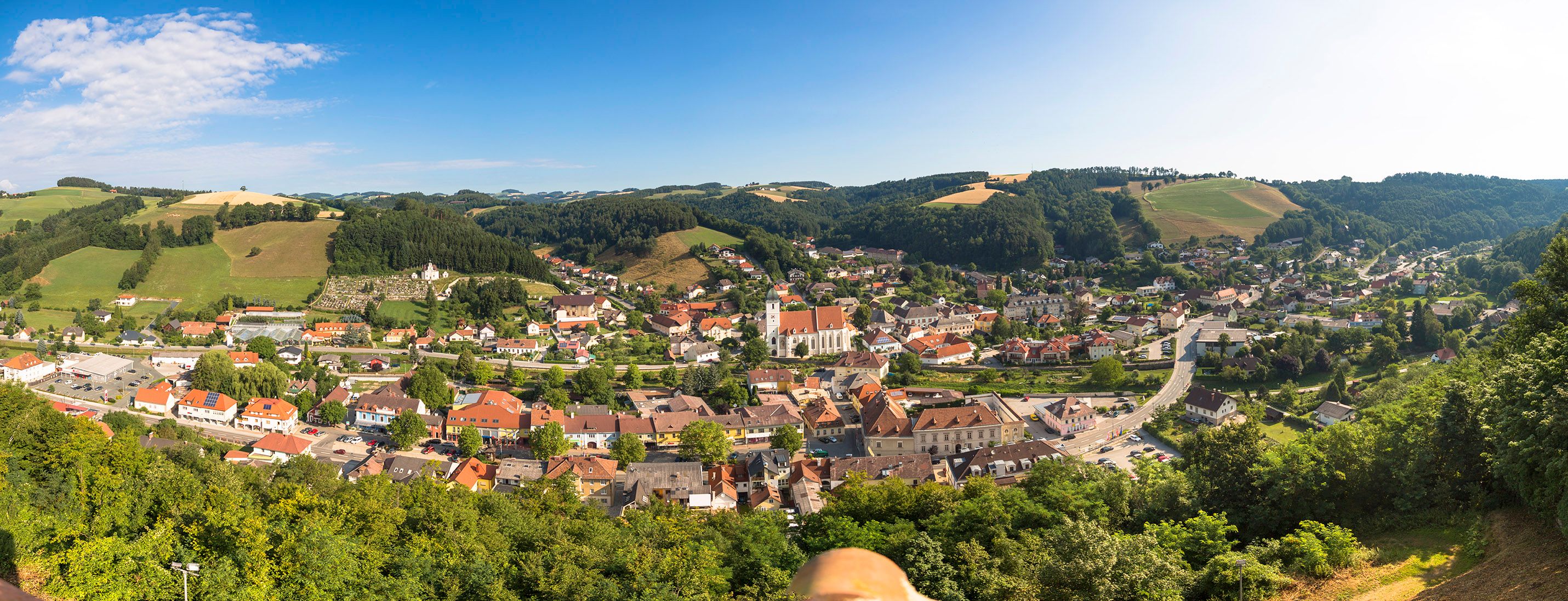 Panoramatický pohľad na Kirchschlag in der Buckelige Welt, obklopený kopcami a lesmi.
