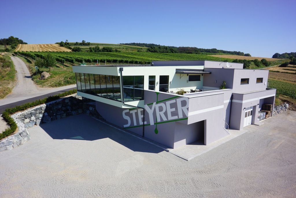 Moderné vinárstvo Steyrer so sklenenou fasádou a okolitými vinicami.